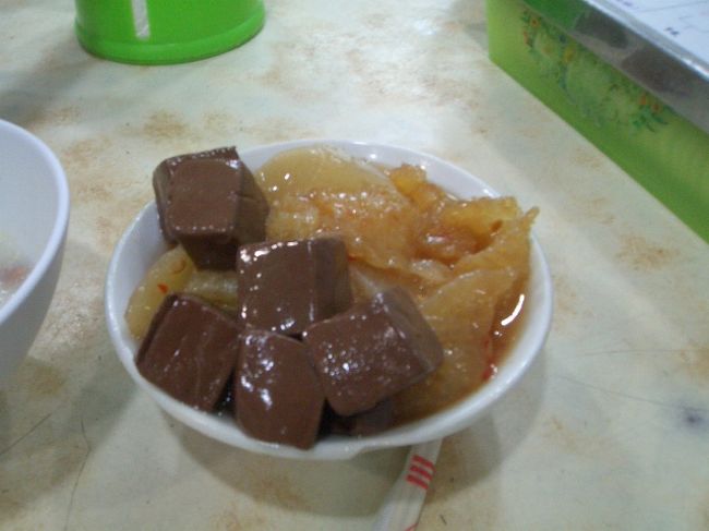 最初のお店はこちらです！<br />http://www.openrice.com/restaurant/sr2.htm?shopid=10817<br /><br />ホント、まず観光客は行かない感じのお店なので地元のエイダさんがいなければ、このお店もわからないし注文もできません！<br /><br />この写真は四角いのが豚の血で、あと豚の皮と大根を煮たのが一緒に入ってます。<br />豚の血はさすがに私は１つしか食べれませんでしたが、エイダさんはパクパク食べてました。<br />生粋の香港っ子、恐るべし！です。