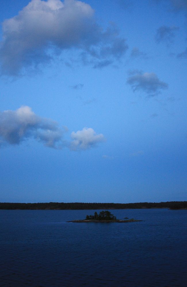 午後10時、甲板に出てみるとその幻想的な世界に息を飲む。<br /><br />これが白夜。<br />静かに、濃いブルーの海に小さな島々が浮かび、昼とも、夜ともつかない空にただよう雲。<br /><br />写真ではずいぶん明るく写っているがもっと暗い。きっと日本で言えば夕方から夜になる一瞬の状態が長い時間続いているのだろう。<br />この風景をわたしは忘れられない。<br />