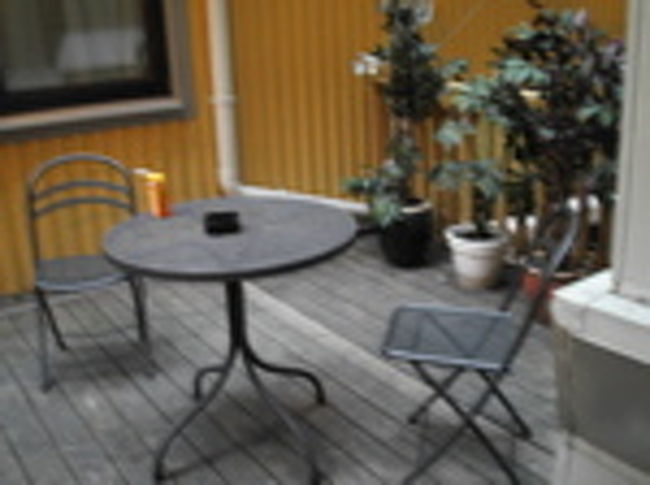 これは2階にあるバックヤード・喫煙場所。 <br />チェックインするとき、「喫煙部屋がいいのですが…」と言うと「えっ…ごめんなさい、全室禁煙なんです。」と言うではないですか！<br />かなりショックでした。<br />ネットで調べた時、公式サイトには載ってなかったのでホテル総合サイトで喫煙室有りって書いてあったから、まさか全部禁煙だとは思いませんでした。<br />どんな汚い場所かと想像してたけど、案外くつろげるように配慮されてました。<br />空を見上げると青空が見えて気持ちいい。<br />ただ、雨や雪の日は厳しいだろうなぁ…。<br />冬とか…。<br />ちなみに2階には他にインターネットルームもあって、紅茶やコーヒーも飲むことができます。 