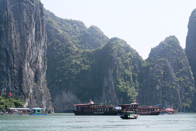 切り立った崖の真下に、船ではない施設が見えました。生簀を持った水上マーケットの一つのようです。大きな船がその近くに停泊していました。