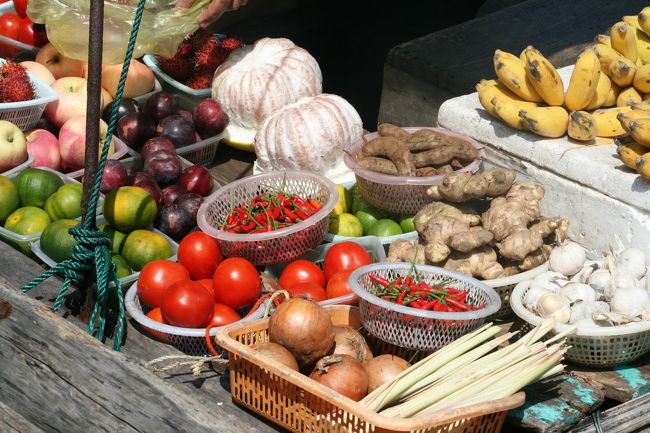 水上マーケットの紹介です。生簀があった場所に横付けして商っていました。野菜や果物が満載です。バナナやミカン、、トマトやショウガなども見えます。