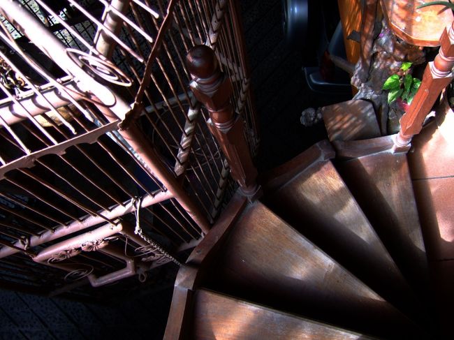 ２階が待合室らしく、怪しげな建物を言われるがまま登っていく。<br />複雑な造りをしていて、中はまるでアミューズメントパーク。<br />表に面した手摺の無い螺旋階段の脇には、人間の子供が簡単に入れるサイズの見た事無いほど巨大な鳥カゴが…。<br />