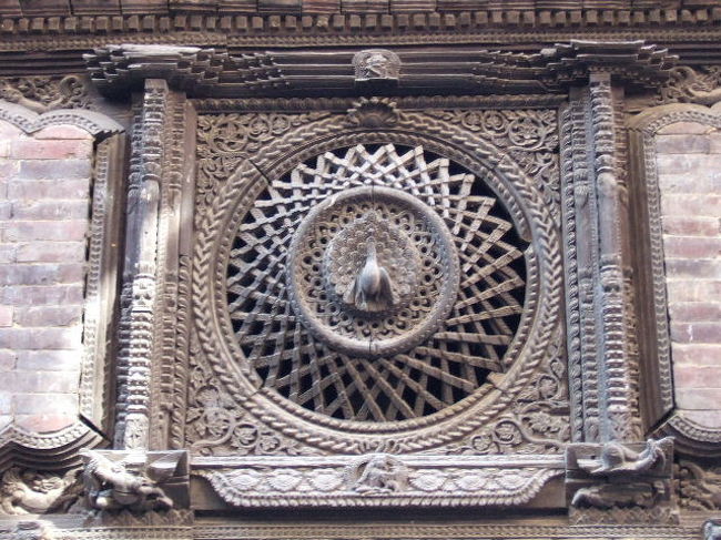 孔雀の窓<br /><br />ダットラヤ寺院の裏側、木彫美術館となっているプジャリ・マート左側面の窓。<br /><br />かつては僧院だった15世紀の建物で、孔雀の窓はネワール彫刻の最高傑作とされる見事なもの。