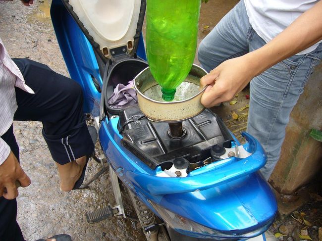 東南アジアでありがちな光景、『街角の簡易ガソリンスタンド』の図。<br />ペットボトルにガソリン…危ないぞー。