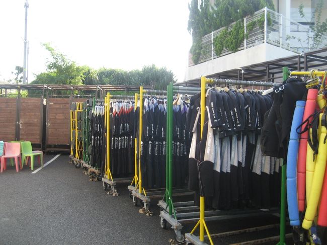 スゴーイ！！<br />このウェットスーツ、マリンシューズの取り揃え具合。<br /><br />奥に見える茶色のドアが、更衣室。<br />手前のカラフルな椅子の上には、陽に当って温かくなったタオルが用意されています。