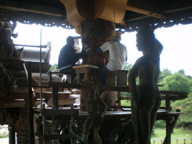 外部軒を支える丸柱を二人掛かりで彫刻してます。<br />上には日本建築のマスのような物が、有りますが、<br />たぶんこれも彫りが入る様です。