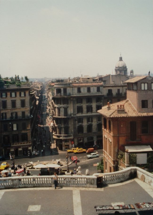 スペイン階段から広場を見下ろす。<br />前方の建物群には、バックなどの有名ブランドの店舗が立ち並んでいる。<br />広場の人出も少ない。