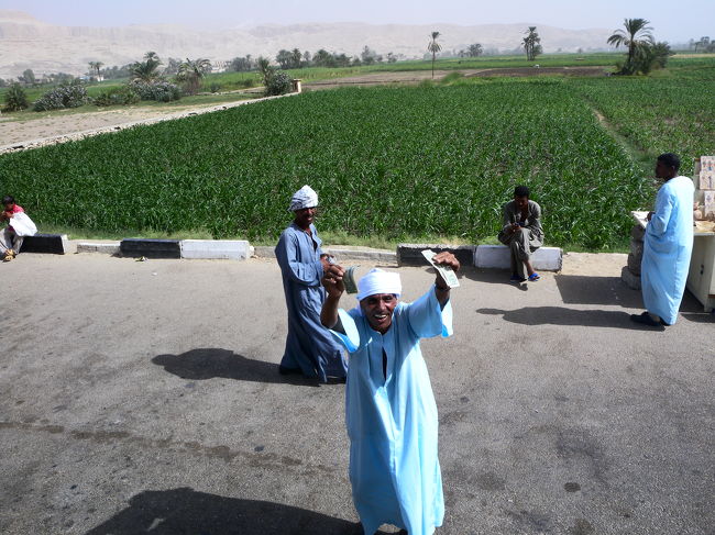 メムノンの巨像まえの駐車場でお土産を売っているおじさん．予想外の売れ行きに大喜びしているところをパチリ！<br /><br />ルクソールを後にします．