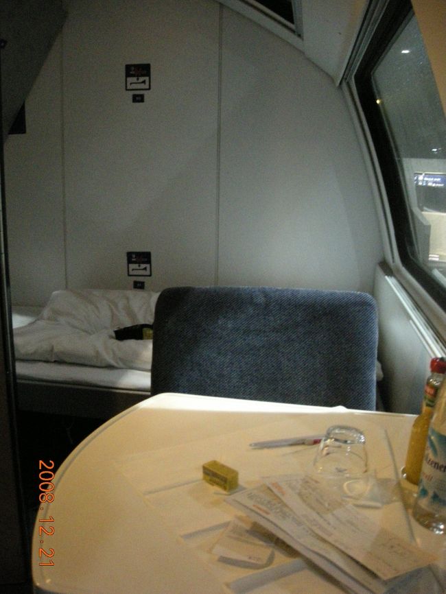 個室。手前は椅子とテーブル。奥にベッドがある。特に車内放送もないまま、いつの間にか出発していた。この旅の欧州で過ごす最後の夜。