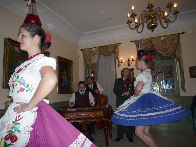 民族衣装で頭にワインを載せて踊る女性