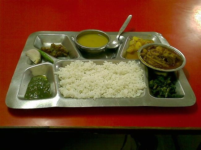 １週間のお休みをいただきネパール旅行にいくことにしました <br />10月1日の晩、羽田より関空乗り継ぎで、今ドーハでカトマンズ行きの飛行機まちです <br />関空を出て早12時間、結構な時間です <br />ドーハは早朝着にて、飛行機を降りた際の朝日が大きく丸くオレンジできれいでした。<br /><br />１０月２日<br />夕方１７時にカトマンズ到着。入国のヴィザの手続き等でほぼ一時間、東京を出発してから約２４時間、やっとついたところ、迎えにきているはずの予約したホテルからの人が見当たらず。<br />しょうがなく、声をかけてきた人の携帯を借りてホテルに電話し、結局その人の車で費用ホテル持ちにてホテルにつれていってもらう。<br />ホテルにてちょっと休憩してその後、夜のカトマンズをちょこっとぶらつき、晩ご飯は和食屋（おふくろの味）でとんかつ定食（笑）２１０ルピーを食して<br />この日は終了。<br /><br />１０月３日<br />ネパールでの初めての朝ということで、やっぱりネパール料理をブランチにて食す（笑）<br />トリベニというお店で、ネパールの定食であるダルバート、タルカリというご飯とカレーと豆のスープに漬物と追加で鶏肉のセット。<br />味はそんなには辛くなく、とうがらしの辛さも適度にあって、とてもおいしい。つけあわせに生の青とうがらしとタマネギをくれたがこれをかじりながら食べると、これが以外といけました。<br />店には地元の人ばかりで、外人はわたし一人だった。<br /><br />