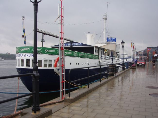 メトロでガラムスタン傍の港の宿にチェックイン。写真の船、実は宿です。もちろん動いたりしません。スウェーデンもノルウェー同様、あまりにも宿・その他物価が高いので、バス・トイレ共同で我慢しましたが、部屋は荷物を置いたら足の踏み場もないほどの狭さ。部屋も汚いです。これで当時のレートで1泊1万円以上なんて、日本だったらとっくにつぶれていますよね。<br />写真に見られるように、スウェーデンでも雨。