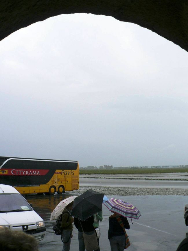 雨の中、バスを待つ人達。<br /><br />