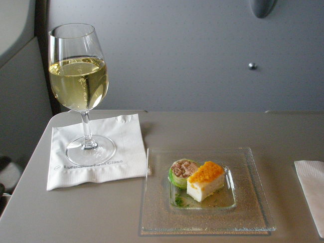 いよいよ機内食の紹介です。<br /><br />これがLHのFクラス機内食です。<br /><br />席についてすぐにウェルカムシャンパンとナッツが出てきたそうですが<br />離陸時に下がられました。<br /><br />離陸して水平飛行になってから、食事のスタートです。<br /><br />メニュー表をいただき、洋食か和食を選択します。<br />その中でもさらに複数のメニューから選ぶことができるようになっています。<br />料理は全て六本木ヒルズにあるホテル、グランドハイアット東京のシェフによるものです。<br /><br />ダンナは洋食を選択。<br />