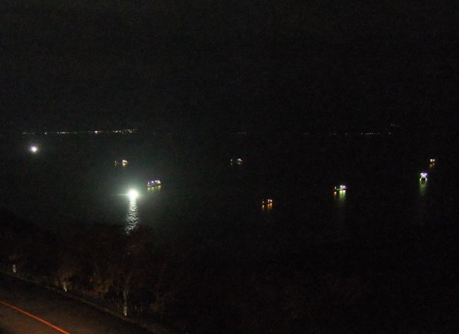 漁火。<br /><br />去年よりも岸に近い所で操業していました。<br />季節によってイカの泳いでいる場所が違うのかな？<br />天気が悪いせいか船の数も少ない…。<br /><br />昨年の漁火↓<br />http://4travel.jp/traveler/rossini/pict/15307790/src.html<br /><br />ちなみにこの昨年の写真の上の方に<br />縦に伸びる光が<br />うっすらと写っているのが分かりますか？<br />これは漁火光柱（いさりびこうちゅう）と言って<br />とても珍しい現象なんだそうです。<br />最近それを知りました。