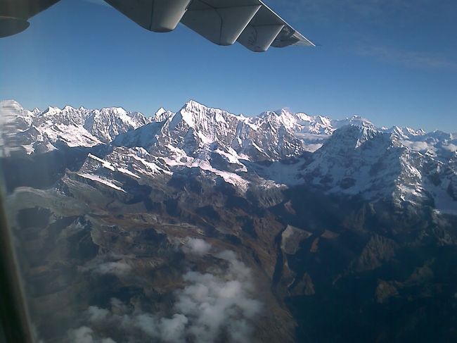 離陸して雲を抜けるとまずは、左側の席から一連の山々が見れ、それから旋回し今度は右側の席から見ることができる。とはいえ、みんな見える方の席によっていましたが。 <br />