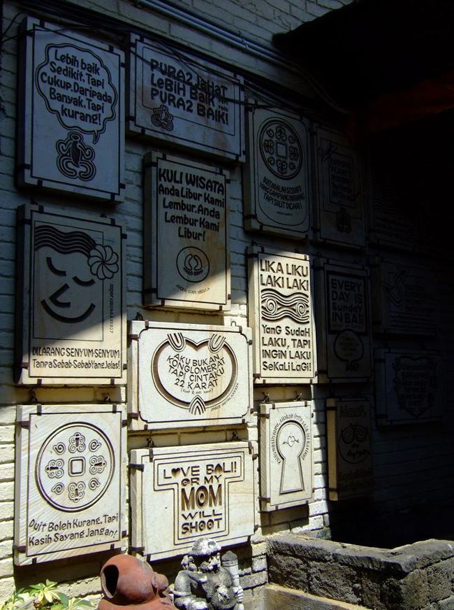 この看板はブランド別なのか、ただデザインが飾られているのかわからないけど、Tシャツのデザインは看板のようなプリントが多くて微妙だった。<br />ブランドのニセモノや、ビールのロゴTシャツに飽きた人は、バリ人好みを探しに行っても面白いかも。<br />