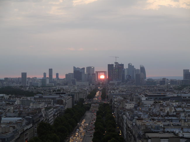 新凱旋門に沈むパリの夕日を凱旋門が望む。