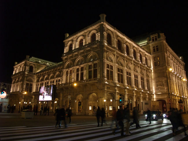 夜のオペラ座（ウィーン国立歌劇場）。<br /><br />壁のスクリーンでは、その日の演目（今日はオペラ）をライブ中継してます。<br /><br />音声もついてて、タダで見れる。<br />音楽の都は大判振る舞いです。<br />こんな環境で勉強できる学生いいなー。