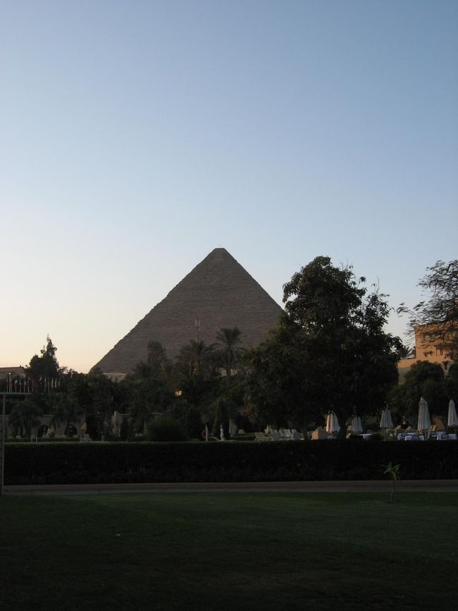 宿泊したのはメナ・ハウス・オベロイというホテル。ピラミッドからわずか３００ｍほどのところにあります。すごくいいホテルであるにも関わらず滞在時間はわずか８時間ほど。昨晩１２時頃に着いて翌９時前には出発となりました。もっとゆっくりしたいなと思えるホテルでした。<br />写真はホテルの部屋からみたクフ王のピラミッド。<br />