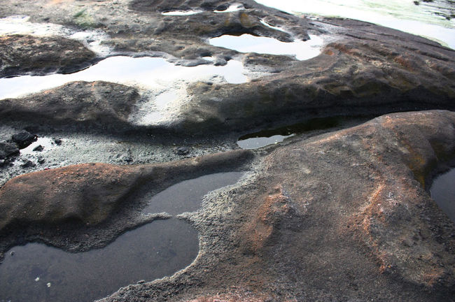 引き潮に取り残された海水が、クレーターのような岩場に残っていて足場が悪い。