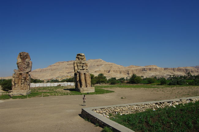 午前中はナイル川を渡り、ルクソールの西岸へ向かいます。<br /><br />途中、「メムノンの巨像」が道端に待ち受けていました。ここで記念撮影。<br /><br />奥に見える山が、王家の谷のある山です。