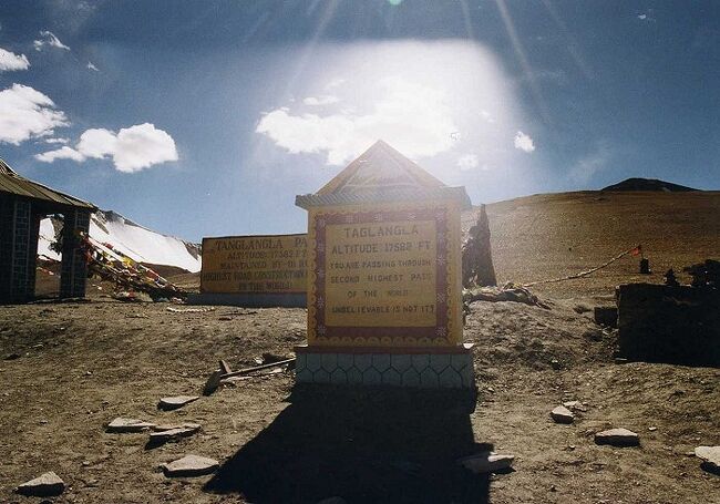 パンクを直すとバスは再びつづら折の道を登り始めた。<br /><br />今度の登りは徹底している。<br />どこまで登っても終わりが見えない。<br /><br />空の色はどんどん青く濃くなってゆく。高度はとっくに5000mを越えていた。<br />そのうち息苦しさを覚え頭が軽く痛み出す。終わりのないつづら折の繰り返しが次第に苦痛になってくる。<br /><br />もういい加減このくらいで打ち止めにしてくれ！<br />そう思い始めた頃、バスは街道の最高地点、「タグラン・ラ（5317m）」に到着した。<br /><br />我々はバスを降りた。<br /><br />峠の上には小さな建物がひとつ。<br />最高地点を示す石碑、それとチョルテンがあった。<br /><br /><br />★★★メインブログの詳細記事はこちら↓★★★<br />標高5,317mの峠を越えてレーの町へ！秘境ラダック地方へのバス旅②（ケーロン～レー）<br />http://search-ethnic.com/travel/to-ladakh2