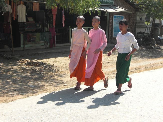 女性の僧はピンク色した袈裟を着ていてとても鮮やかです。横の緑のスカートの子は中学生の服装なんで、学校帰りっぽいです。