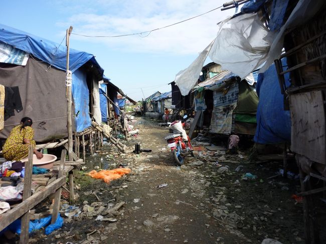 本日の予定<br />ＳＶＡ事務所訪問＜事業視察＞　⇒　スラムの現状と子供たちとの触れ合い　⇒　午後プーサットへ小型マイクロバスで移動（約4時間）<br />←スラムの様子　今は乾期で水はないが雨季は水が溜まる。今でも水が引かない所もある。トイレはない。　