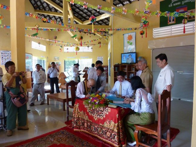 いよいよ式も最後になりました。<br /><br />図書館内部で　サインをするＫ氏　そして手前はドレスアップした校長先生　<br /><br />ここでも　参加した日本人全員が記念のサインをさせていただく。<br />