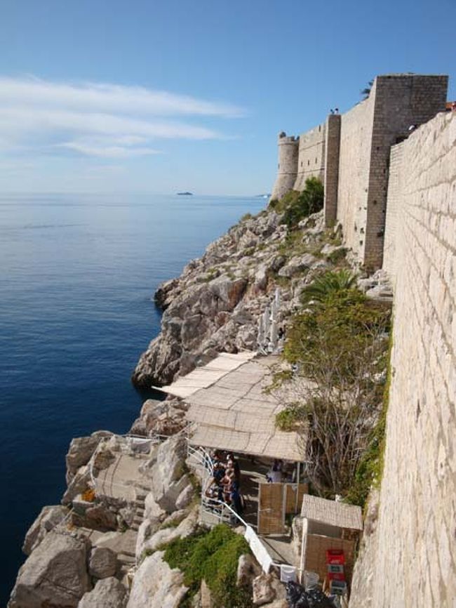 ←ドブロヴニク城壁遊歩道からの眺め<br /><br />城壁の南面は絶壁になっていますが、わずかなスペースにへばりつくように2カ所の公共ビーチがあるそうです。<br />この休憩所には、海からしかアプローチできないようです。<br /><br />私たちが旅行した頃、ドブロヴニクも思いがけず急に寒くなったとききましたが、海の中で泳ぐ人の姿も見えました。