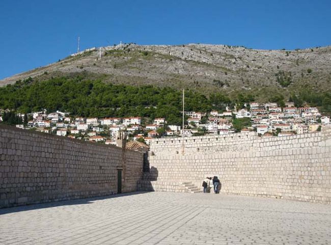 ←ドブロヴニクの城壁遊歩道からの眺め<br /><br />「聖イヴァン要塞」の正面に見える標高412メートルのスルジ山には、かつて山頂までのロープウェイがありました。<br />しかし、1991年のクロアチア独立戦争の際に、旧ユーゴスラヴィア連邦軍によって破壊されてしましました。<br />（2009年中に復旧予定）<br /><br />スルジ山の山頂には、19世紀初めナポレオンが贈ったという白い十字架がありましたが、現在あるものは戦争後に建て直されたものとのこと。