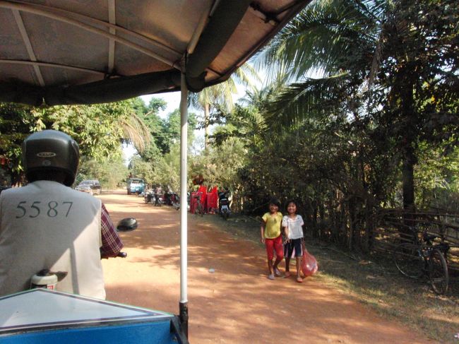 食事が終ったところで、<br />次は、一ノ瀬さんが眠る場所に行きたい。<br /><br />でもその場所がわからない。<br />バンテアイスレイの方向だということしか<br />わからない。<br /><br />ダメもとで、トゥクトゥクの運転手に<br />聞くと、「Ｉ know！」と即答！<br /><br />やった！<br /><br />シェムリアップから３０分ほど走ると、<br />ようやく近づいてきた。<br /><br />そこの町の子供が、<br />やたらとあいさつしてくれる＾＾