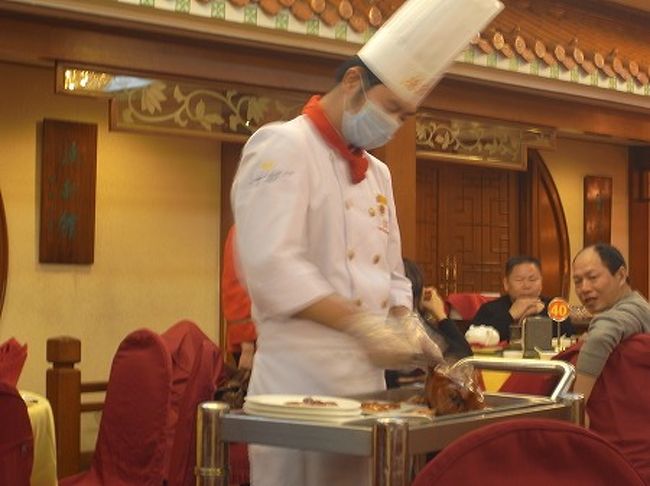 こんがり焼かれたダックをシェフがテーブルの横で解体します。