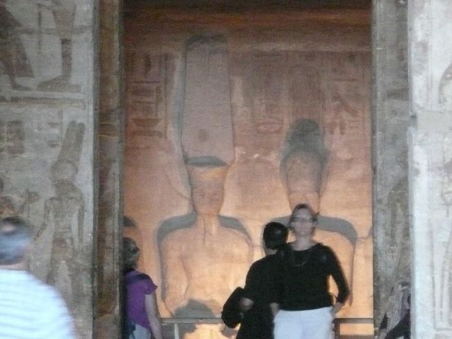 こちらが大神殿の至聖所。入口からカメラのズームを最大にして撮った写真。本来4体の神像が並んでいるが、両脇の2体は壁の影になってて映らなかった・・しかも中央部分に他の観光客が・・・・でも<br /><br />日本製の高性能カメラをなめるな!!!<br /><br />ちなみに後ろに見えている神像は左がアムン・ラー神、右が神格化したラムセス2世、だそうだ。