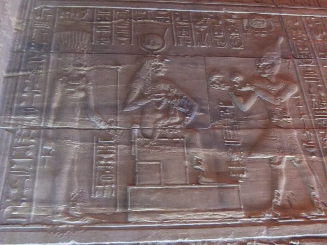 正面向かって右の壁の上側には、このようなレリーフがあります。中央のイシスがホルスに乳をあげています。右側では多分、ファラオがワイン壺を捧げています。