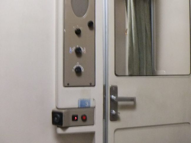 入口にはドアと鍵があります。鍵は内側からしかかけられませんので、トイレなどに出かける時は貴重品を持っていくよう注意しなければなりません。入口のドアの左横には、縦に３つ黒いダイヤルが並んでいます（一番上の灰色の楕円形は確かスピーカーです）。