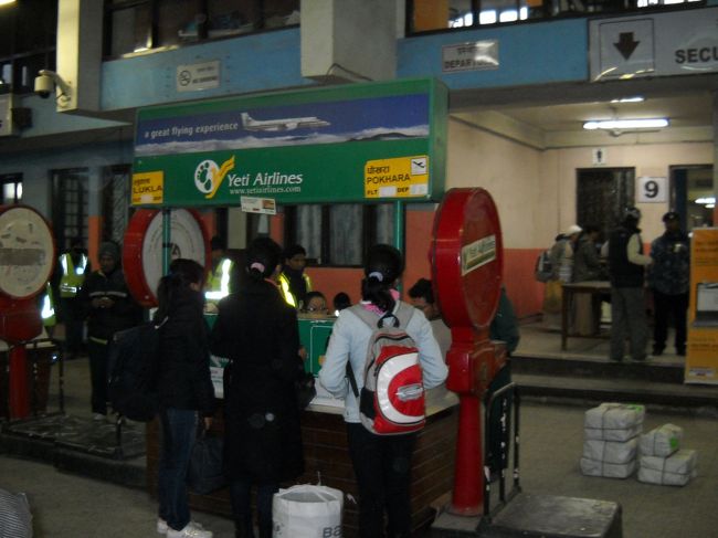 朝6時過ぎにホテルをチェックアウトして空港へ。<br />タクシーを呼んでくれたホテルの人は「350ルピー」と言っていたが、空港に着くと運ちゃんは「500ルピーだ」と言う。空港と言っても真っ暗で殺風景な場所。人気もない。恐かったので言われたとおりの金額を支払う。<br /><br />ポカラまでの飛行機は「Yeti Airlines」。HPで購入した。<br /><br />「ネットでの購入方法」は、<br />日程と行き先、自分のメールアドレス、コメント欄に希望時間などを書き込んで送信する→<br /><br />便名や金額が書かれたメールが返信される→<br /><br />そのメールに添付されているフォームに名前、パスポート番号、購入用のクレジットカードのナンバーなどを記入し、パスポートとクレジットカードのコピーと共にFaxまたはメールに添付して返信する→<br /><br />確認の返信が送られてくる。ここに航空券を受け取ることが出来る場所の案内が載っていた。<br />カトマンドゥ空港・国内線の中にもオフィスがあったので、私たちは当日そこで航空券を受け取った。<br /><br />写真はYeti Airlinesのチェックインカウンター。この大きな秤で荷物の重さを量ります。<br />