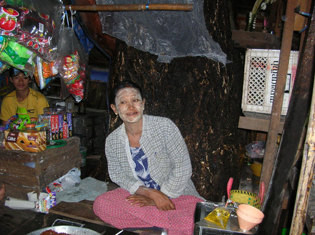 注目してほしいのはタナカを塗りたくった女性ではなく、その後ろです。ちょっとわかりずらいですが大きな木がはえてます。木が立っている所に強引に店を出されてます。 