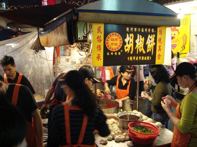 饒河街観光夜市の大門をくぐって、まず目につくのがこの胡椒餅屋に並ぶすごい行列です。<br />僕たち夫婦も３０番目位に並びました。