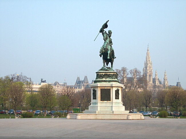 フォルクス庭園を抜けて、そのまま英雄広場へと流れ込みました。 <br /><br />通って来たところを振り返って写真を撮っているので、カール大公騎馬像の後ろにはフォルクス庭園、その後ろには市庁舎が見えています。 <br />最初に英雄広場に来た時、この風景を見て市庁舎をお城を勘違いしてしまったんです。 <br />その気持ちもわからなくはない、でしょ？