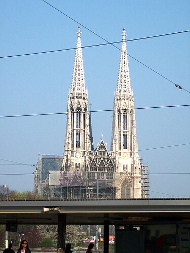 特に行くあてもないんですが、シティマップによると近くに塔のある教会やウィーン大学があるらしい？ということでただひたすら歩く。 <br />ショッテンリンク沿いまで頑張って歩いてみると…塔が見えました！<br /><br />2本ぴょこんと建っている塔が目印のボティーフ教会。 <br />ゴシック系で素敵そうだけど、今の私には遠すぎる。 <br />この時はまだシシィ博物館を見る予定だったので9時に間に合うように王宮に戻りたいと思ってましたし。 <br />遠目に見て写真を撮って、戻りはバスでシュシュッと。 <br />結局王宮の展示は上で書いたように時間がかかりすぎて無理なので、果てさてどうしたものか…。 <br />いきなり1時間自由時間が増えたので、使い道を考えていません。