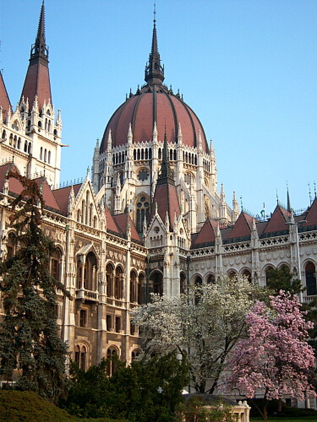 チェックアウトしようと思ったら受付に誰もいなかったので、置き手紙とカギを残して出てきました。 <br />オートロックだし盗られたりしない、よね……？ <br />7時半前に宿を出た理由はただ一つ。8時から国会議事堂見学チケットが発売されるから。 <br />国会議事堂はガイドツアーでしか入れず、英語は10時、12時、14時の3回。 <br />事前の予約は受け付けていないので、当日議事堂に行ってチケットを買うしかありません。 <br />ハンガリー政府のHPを見たら1回のツアーは定員50人とあったので、これは朝一で買いに行かないといろんなスケジュールがズレる！と思い、眠くても何でも早くに出たわけです。 <br />議事堂へは地下鉄2号線、Kossuth Lajos Ter駅下車すぐ。 <br />出口を出たら議事堂が存在感溢れる感じで建っているので絶対に迷うことはありません。<br /><br />ドナウ川とセットで見なくても美しい国会議事堂。 <br />365の尖塔があるらしいです。 <br />お花も今が季節なので議事堂の横で咲き誇っていました。