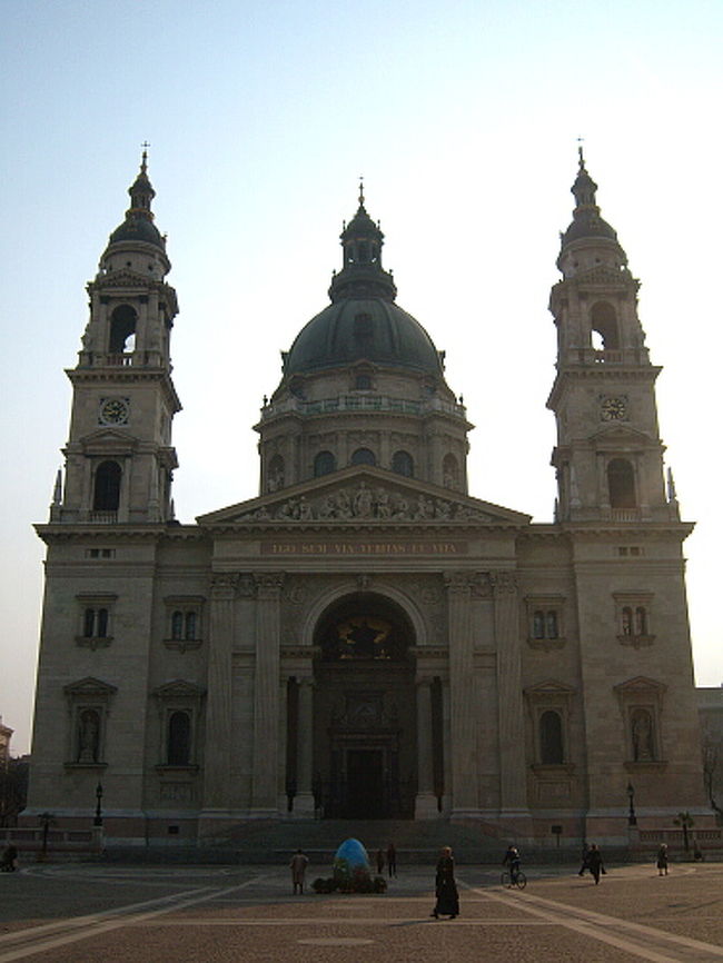 予想より時間を取られてしまいましたが、10時からのガイドツアー前に聖イシュトバーン大聖堂を見学します。 <br />国会議事堂付近を走っているトラム2番に乗車し、くさり橋前で降り、105番バスに乗り換えて近くまで行きました。 <br />2番はドナウ川沿いを走るトラムなので眺めがよくて好き。 <br />イシュトバーンは大通り沿いに建っているのですが、道路にはおしりを向けている感じで、正面入り口には回りこむ必要があります。 <br />入口の前はでっかい広場になっていました。<br /><br />聖イシュトバーン大聖堂。長方形の土台の上に塔が2本、真ん中にはドーム。 <br />広場は朝早いのでまだ閑散としています。