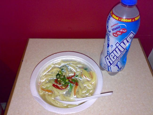 すごい写真になってますが、やさしいお味のベジヌードル。<br /><br />うどんだったのがすごく意外だったけど、別添えのチリをがっつり入れて（結果、入れすぎ）私好みの味付けに。<br /><br />お夜食には最適。<br /><br />Reviveは炭酸系スポーツ飲料。<br /><br />　RM2 (\50)<br /><br />リバーサファリ事件以降、私を脱水症状から救ってくれた。<br /><br />まさにネーミングどおりの素晴らしい働き。