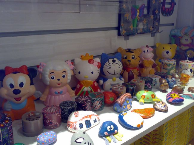 入って早々、足が止まる。<br /><br />わぁ〜（驚）。<br /><br />いわゆるDIY的なお店なので、このキットを使えばあなたもこんなミニーちゃんやあんなドラちゃんが作れますよ〜というサンプルなのだが。<br /><br />ミニーとキティにはさまれた、、いったい何者！？