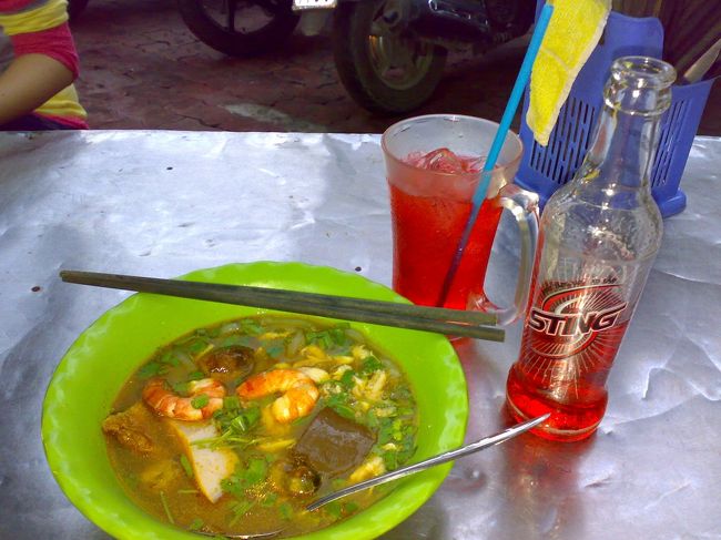 けっこう待って、やっときた〜。<br /><br />トムヤムクン風スープの中に、透明の太くて柔らかい麺が入ってる。<br /><br />だいたいがトムヤム好きだから、うまっ。<br /><br />　麺 VND32,000 (\168) <br />　ジュース VND8,000 (\42)<br /><br />今、計算してみてふと思った。<br /><br />けっこう高くない？<br /><br />物価、そんなに激安じゃあないの？？