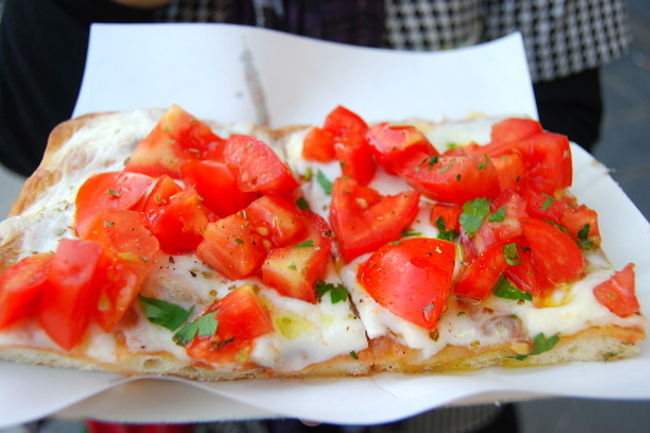 途中、とても美味しそうなピッツァリアを見つけたので遅めの昼食をとることに。<br />たっぷりのモッツァレラチーズをのせて焼いたパンのような生地の上にどっさりとフレッシュトマトがのったピッツァ。<br />ショーウィンドウ越しに何等分かに切ってあるものを指差すと「どれくらい？」と店員さん。<br />更にそのうち1切れを指して「この半分？半分の半分？」と聞いてくれる。<br />チーズも臭みがなくミルキーな味わいで、フルーティーなオリーブオイルと甘く食感のいいトマトがとても美味しいピザでした。