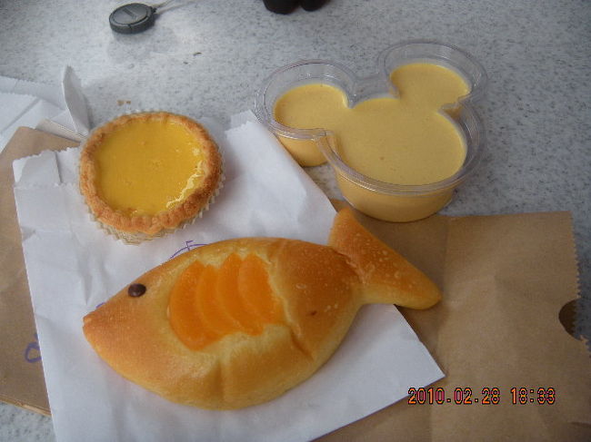 おやつ。<br />エッグタルト（おいしい！）<br />ミッキーの形のマンゴープリン（こどもはちょっと食べてみたが口に合わなかったようだ。わたしにはおいしかった！）<br />魚型のパン（こちらの味はイマイチ）<br />＋コカコーラ、合計で１０１香港ドルでした。<br /><br />ちなみに「キャラメルポップコーン」は２０香港ドルでした。東京ディズニーランドのように大きなキャラクターの入れ物にはいったポップコーンはうっていませんでした。紙パック入りのものだけです。<br />東京ほどポップコーンは人気がないようです。<br />並んでいる時間が少ないのでポップコーンを頬張る時間もあまりありません。例え並んでも、持参したソーセージをかじるなどして、ポップコーンを食べながら並んでいる人はいませんでした。