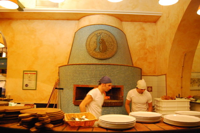 バスの中から私が見ていたのは、この石釜。<br />直感は大当たり、地元客でとても賑わっていて店内には席が空くのを待っているお客さんがたくさんいました。<br />私たちも順番待ちの紙に名前を書いて待っていたのですが、後からもどんどんお客さんがやってきて店内に待ちきれないくらいの人たちが大勢、外で順番待ちを始めました。<br />まさに行列のできるピッツァリア。